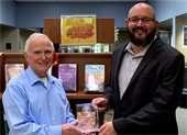 Friendswood Library Director Matthew Riley (right) presents Harold Benson with the 2020 Friendswood Library Outstanding Programming Award for his planning and execution of a series of educational and informative Library events celebrating the 50th Anniversary of the Lunar Landing.